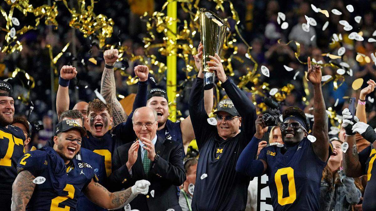 El entrenador de los Wolverines de Michigan Jim Harbaugh celebra con los jugadores del equipo tras derrotar a los Huskies de Washington por el título nacional del football universitario, en el partido celebrado el 8 de enero de 2023 en Houston.