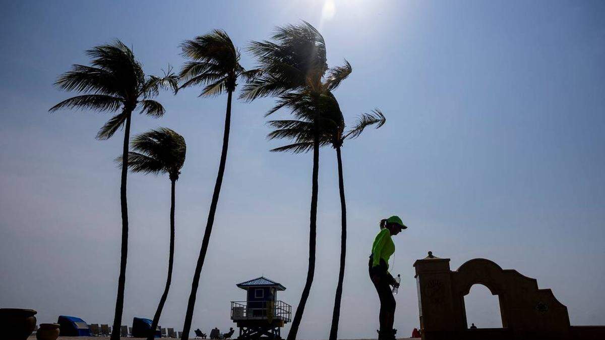 Una mujer camina por el malecón de madera de Hollywood Beach con temperaturas en los 90 grados Fahrenheit, el 14 de mayo de 2024.