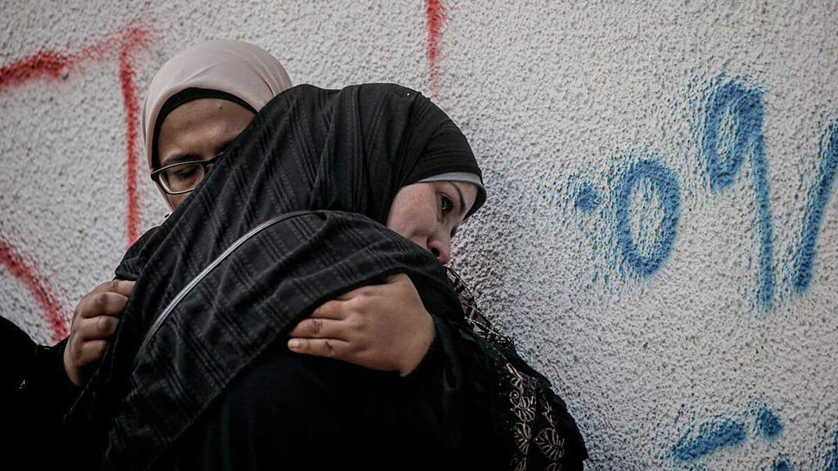 Relatives grieve the loss of a loved one outside Al-Shifa hospital in Gaza City, Palestinian territories on October 28, 2025. According to the Palestinian Ministry of Health in Gaza, at least 110 Palestinians were killed and several others wounded following Israeli air strikes in Gaza Strip. (Photo by Abood Abusalama / Middle East Images via AFP) (Photo by ABOOD ABUSALAMA/Middle East Images/AFP via Getty Images)