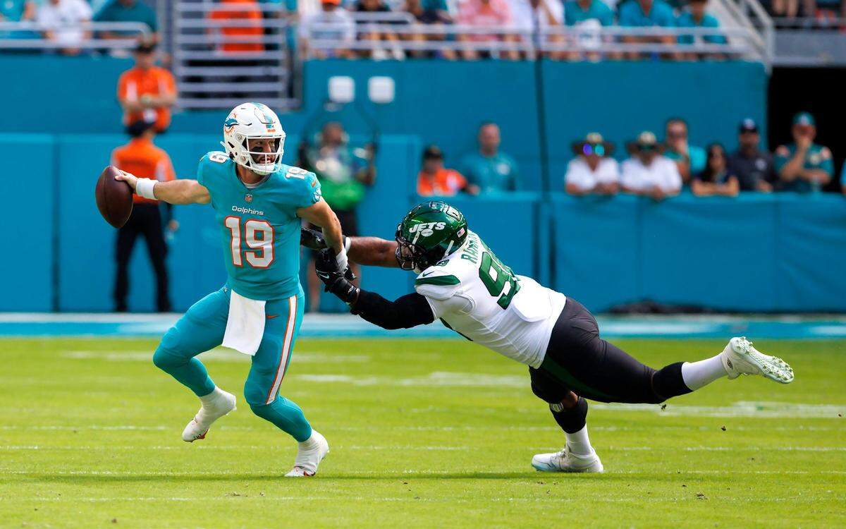 El quarterback de los Dolphins Skylar Thompson (19) evita el derribo de Sheldon Rankins en el primer cuarto del partido ante los Jets de New York, celebrado el 8 de enero de 2023 en el Hard Rock Stadium, en Miami Gardens, Florida.