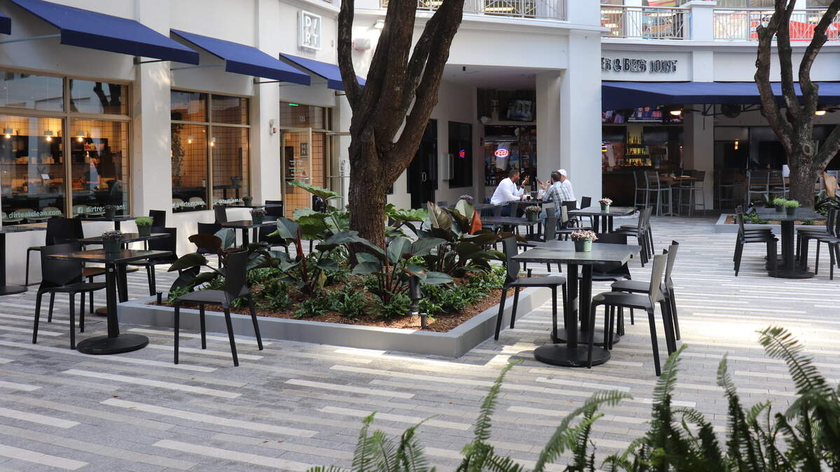 La plaza con mesas al aire en medio de la vegetación se mantendrá como uno de los atractivos de Mary Brickell Village.