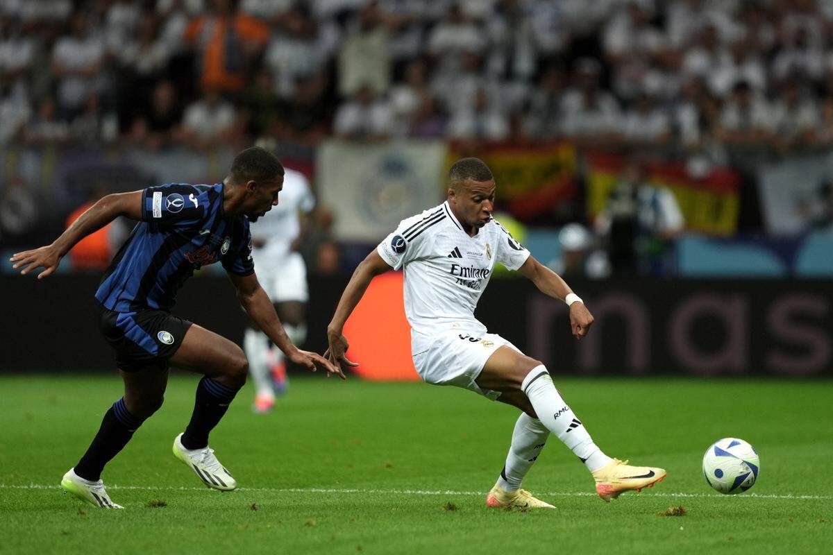 El jugador del Real Madrid Kylian Mbappé (der.) conduce el balón en el partido ante Atalanta en la final de la Supercopa de Europa, celebrada el 14 de agosto de 2024 en Varsovia, Polonia.