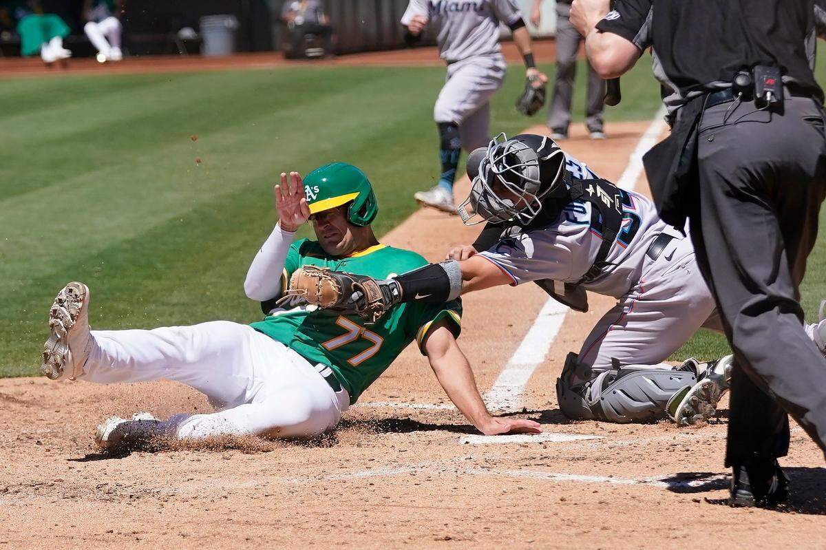 El segunda base de los Atlétcios Jonah Bride es puesto out por el receptor de los Marlins Nick Fortes, en el sexto inning del partido celebrado el 24 de agosto de 2022 en Oakland.