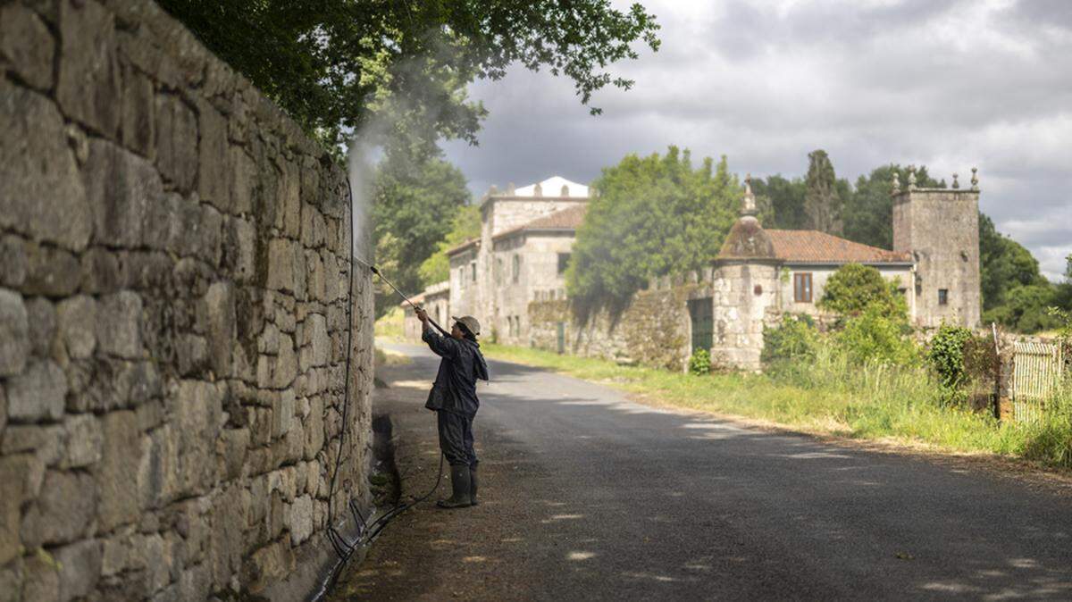Un trabajador limpia el muro de la vivienda que ha comprado Julio Iglesias en Piñor (Ourense). En Piñor, un pueblo ourensano que apenas sobrepasa el millar de habitantes y que es conocido por su cantidad de fábricas de ataúdes, hay más revuelo de lo habitual porque Julio Iglesias, cantante de fama internacional, ha comprado allí una casa solariega.