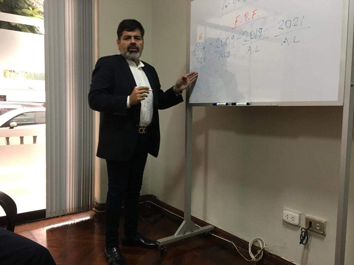 El presidente de la ADFP Oscar Romero explica en una pizarra en sus oficinas en Lima cómo la FPF eligió su actual directiva bajo estatutos declarados nulos. .