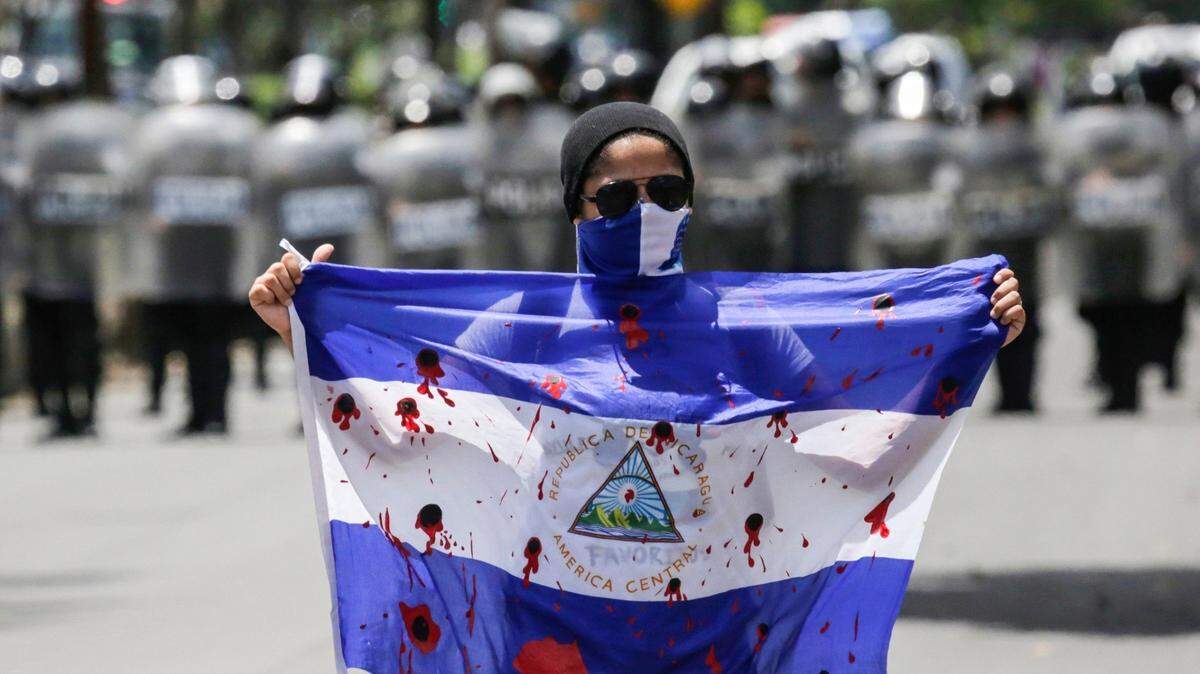 Un manifestante muestra una bandera sangrienta durante una protesta contra el gobierno del presidente nicaragüense, Daniel Ortega, en Managua, el 16 de septiembre de 2018. (Photo by Inti Ocon / AFP)