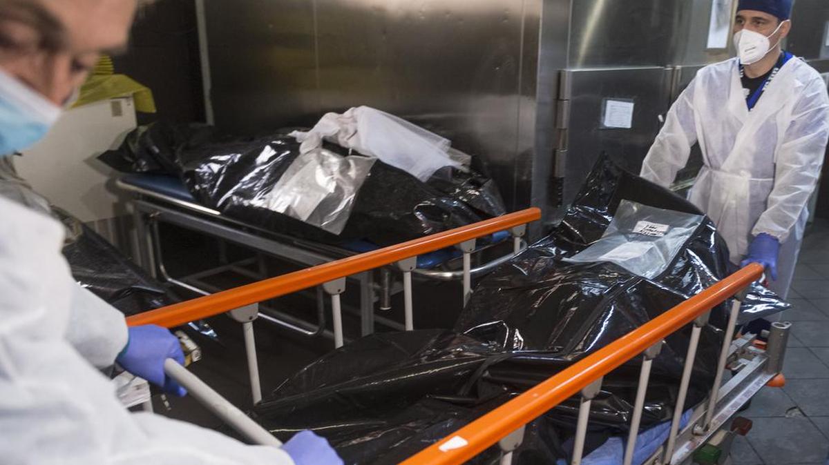 Los empleados de la funeraria retiran un ataúd con una víctima de COVID-19 del Hospital Universitario de Bucarest, Rumania, el viernes 29 de octubre de 2021. (Foto AP / Alexandru Dobre)