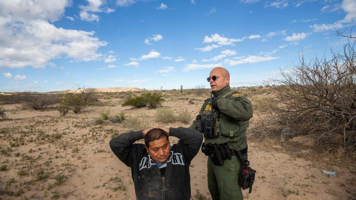 El agente de la Patrulla Fronteriza Orlando Marrero-Rubio detiene a dos migrantes que habían ingresado a los EEUU sin la documentación adecuada en Sunland Park, Nuevo México, en marzo de 2023.