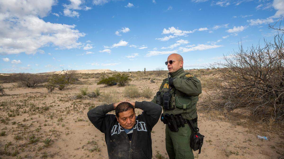 El agente de la Patrulla Fronteriza Orlando Marrero-Rubio detiene a dos migrantes que habían ingresado a los EEUU sin la documentación adecuada en Sunland Park, Nuevo México, en marzo de 2023.