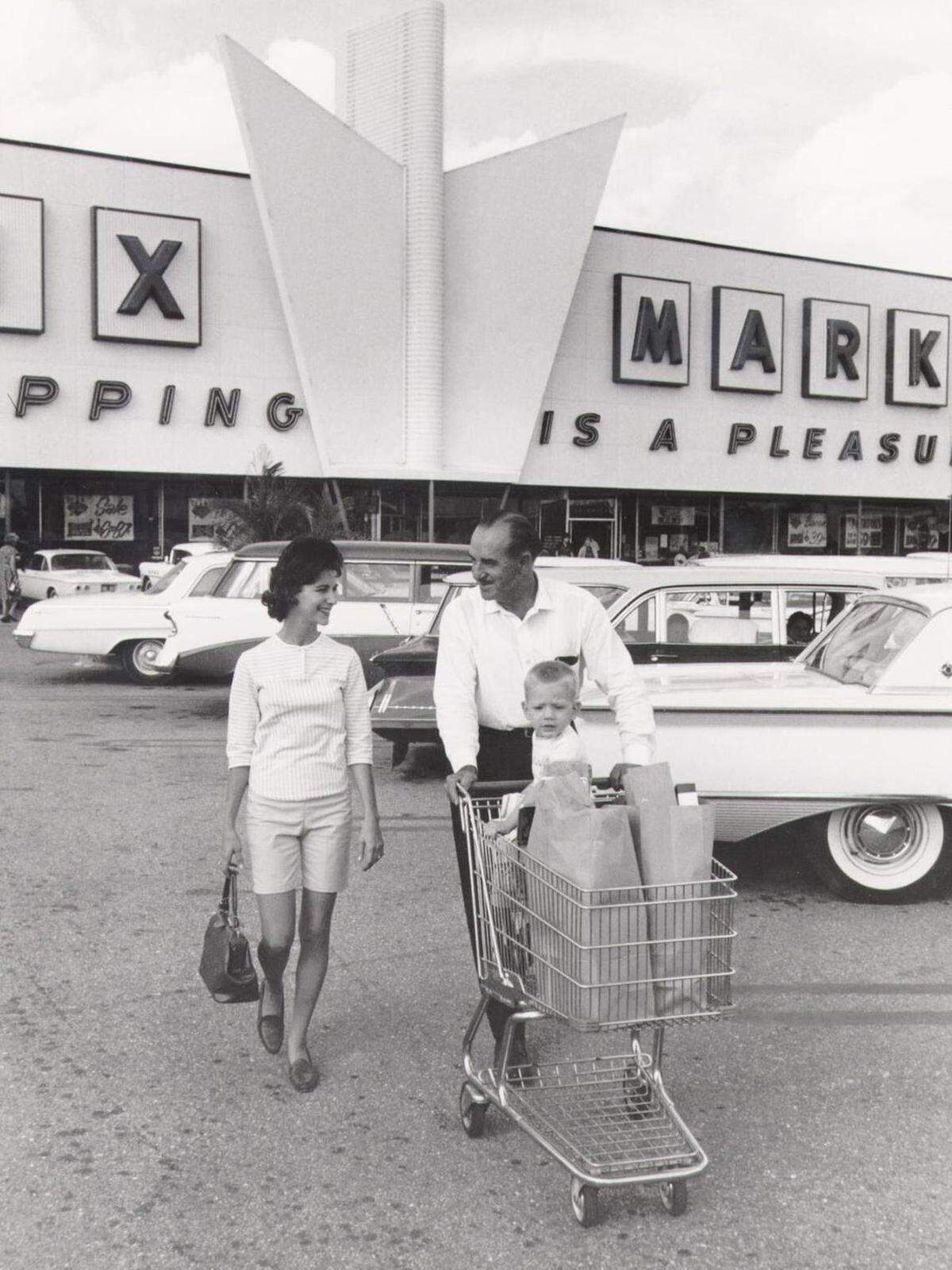 El fundador de Publix, George Jenkins, lleva las bolsas de la compra de una clienta a su auto en esta foto sin fecha.