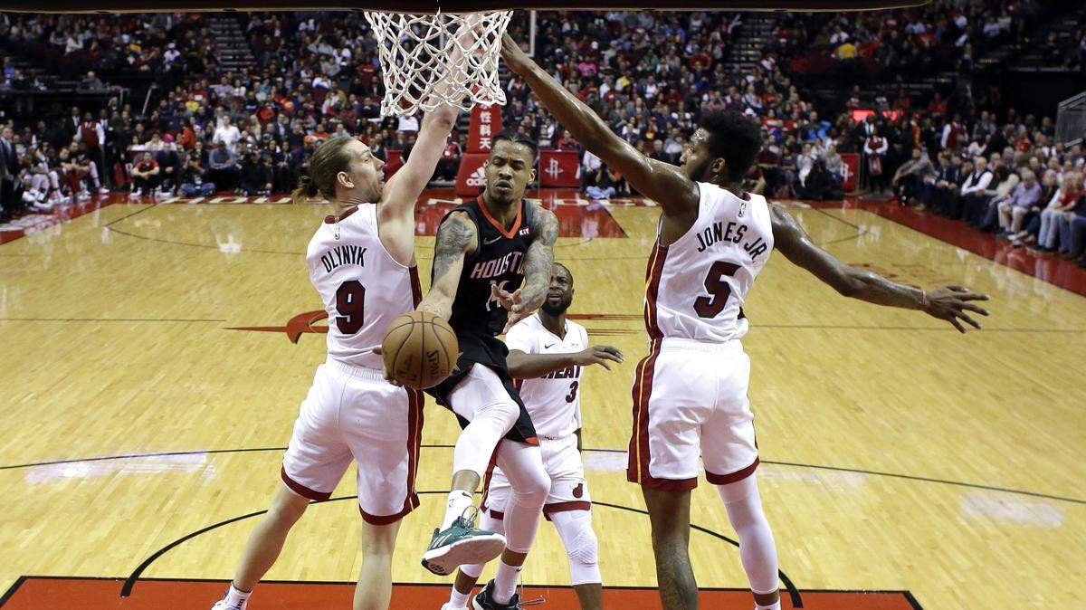 El jugador de los Rockets Gerald Green (14) entra al aro ante la marca de Kelly Olynyk (izq.) y Derrick Jones, del Heat, en el partido efectuado el 28 de febrero de 2019 en Houston.