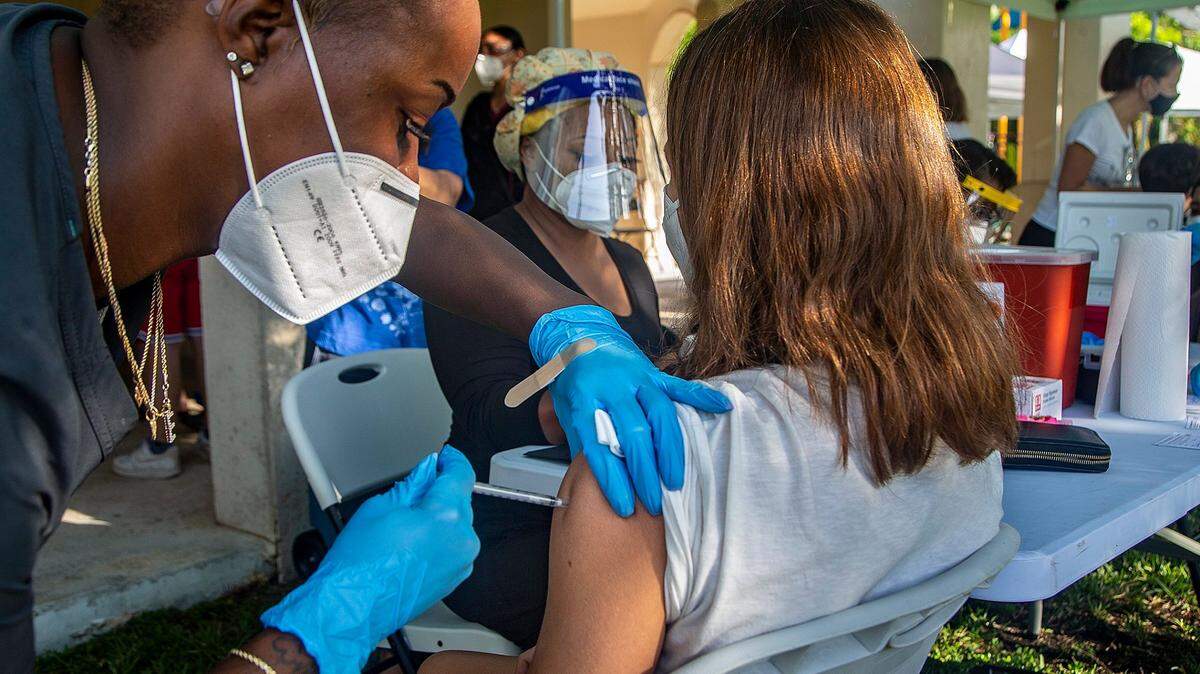 Una niña de 14 años recibe su primera vacuna Pfizer COVID-19 de la enfermera Erica Goodin en la Clínica Infantil de South Miami el 15 de mayo del 2021.