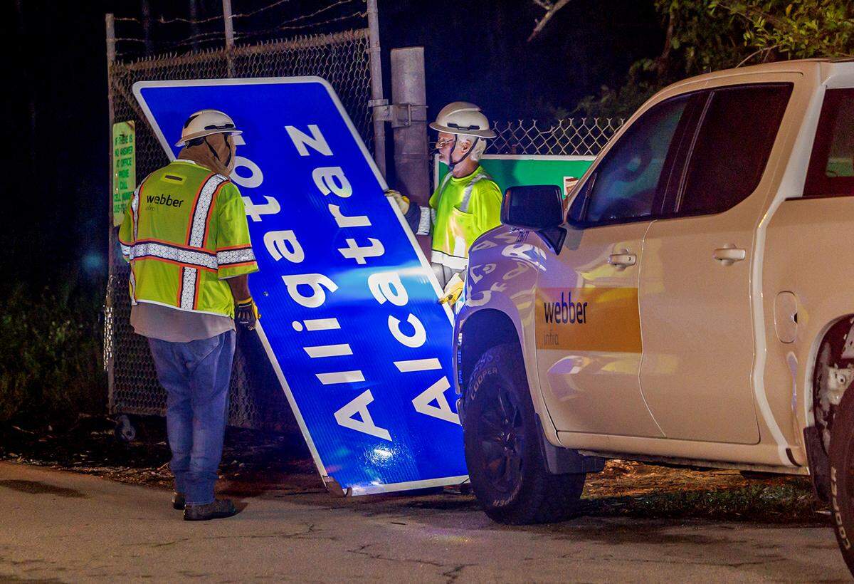 Dos trabajadores instalaron un nuevo cartel con el texto Alligator Alcatraz en la entrada del lugar, encima del antiguo letrero del Aeropuerto de Entrenamiento y Transición Dade-Collier en el sitio ubicado en Ochopee, Florida, en la noche del miércoles 2 de julio de 2025.