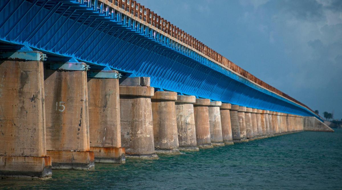 Este lunes 10 de enero de 2022, una foto aérea de un dron proporcionada por Florida Keys News Bureau muestra el puente Old Seven Mile listo para su reapertura el miércoles 12 de enero de 2022 a peatones, ciclistas, pescadores y visitantes de Pigeon Key (isla se muestra en la foto). El viejo puente originalmente era parte del Ferrocarril Over-Sea de los Cayos de Florida de Henry Flagler que se completó en 1912. El ferrocarril cesó sus operaciones en 1935 y se convirtió en una carretera que se inauguró en 1938. En 1982, se completó la construcción de un nuevo Puente de Siete Millas , detrás, que continúa transportando vehículos motorizados entre el sur de la Florida continental a lo largo de los Cayos hasta Cayo Hueso. (Andy Newman/Oficina de noticias de los Cayos de Florida vía AP)