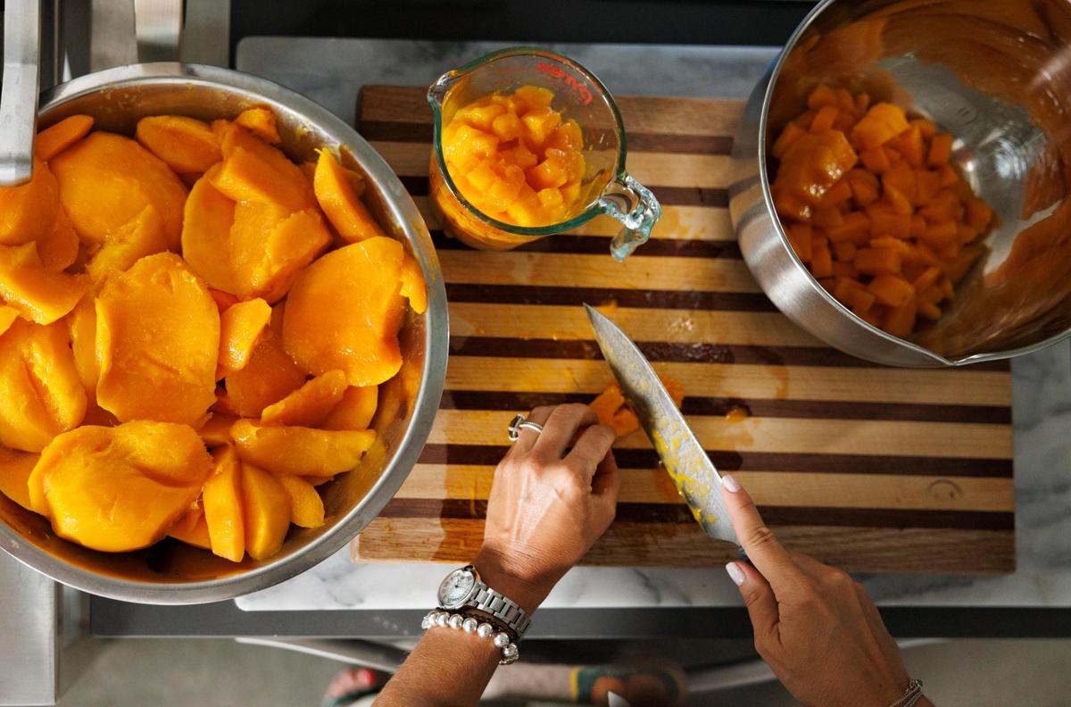 Natalia Martínez-Kalinina trocea mangos frescos en su casa de Miami.