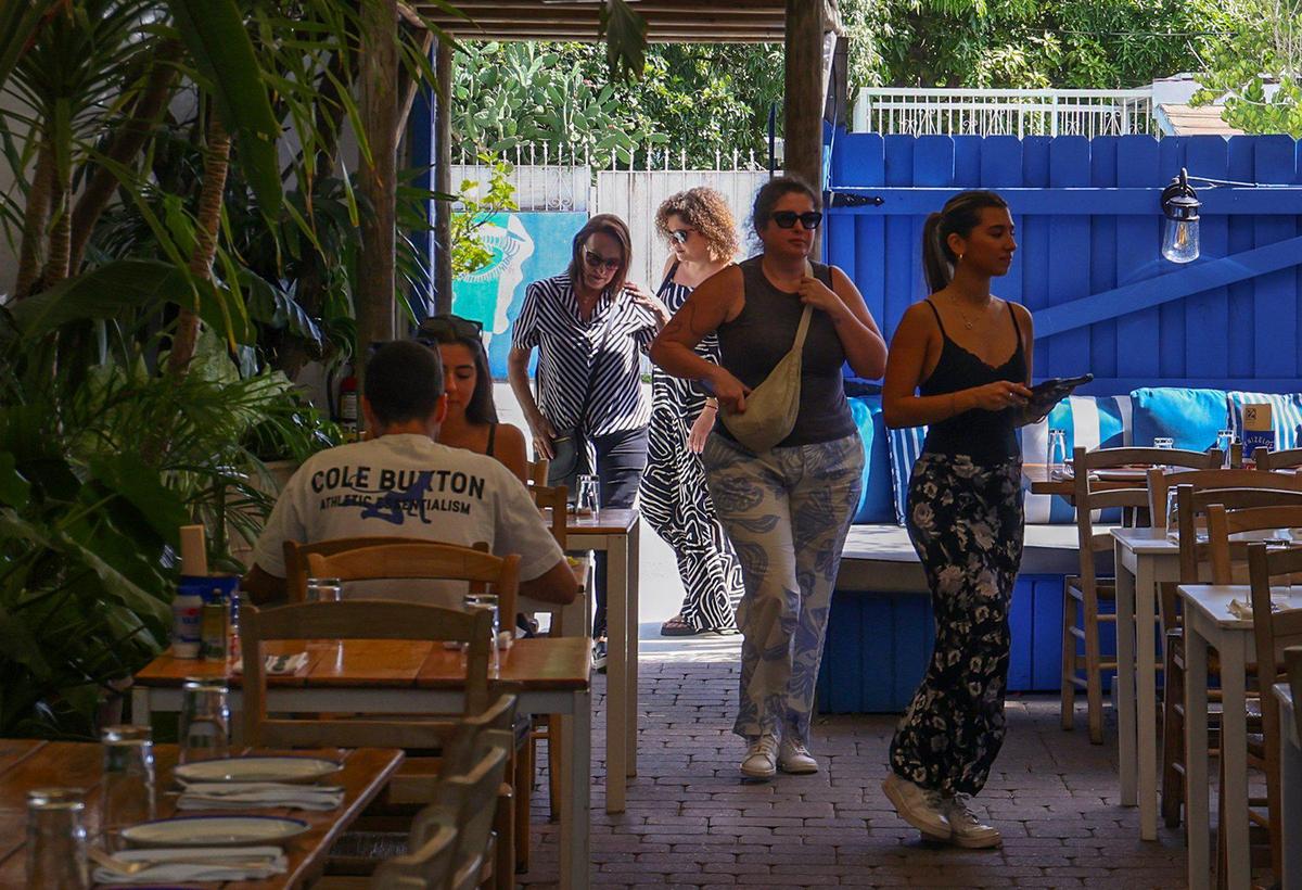 Los comensales a la hora del almuerzo son escoltados a su mesa en el patio del Mandolin Aegean Bistro.