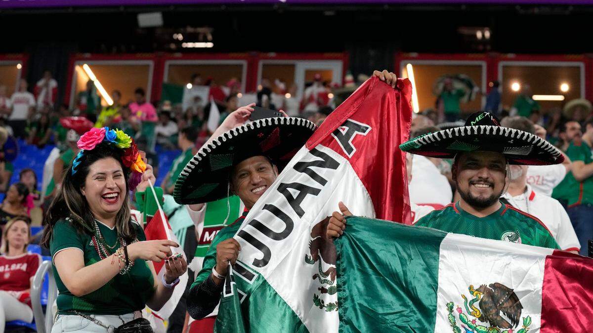 Aficionados mexicanos sostienen su bandera nacional durante el partido de fútbol del grupo C de la Copa Mundial, entre México y Polonia, en el Estadio 974 en Doha, Qatar, el martes 22 de noviembre de 2022. (Foto AP/Aijaz Rahi)