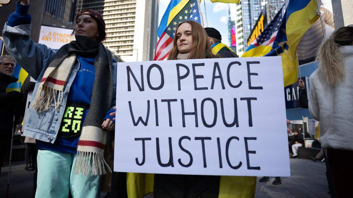 Cientos de personas participan en una manifestación en apoyo de Ucrania en contra de la invasión rusa, el domingo 9 de marzo de 2025, en Times Square, Nueva York. La pancarta dice “No hay paz sin justicia”. 