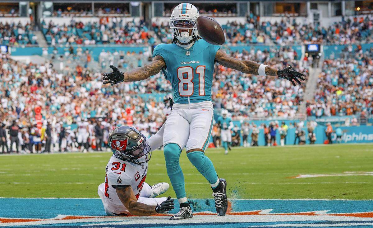 El wide receiver de los Dolphins Theo Wease Jr. (81) anota un touchdown sobre la marca del safety de los Buccaneers de Tampa Bay Antoine Winfield Jr., en el partido celebrado el 28 de diciembre de 2025 en el Hard Rock Stadium en Miami Gardens, Florida. 