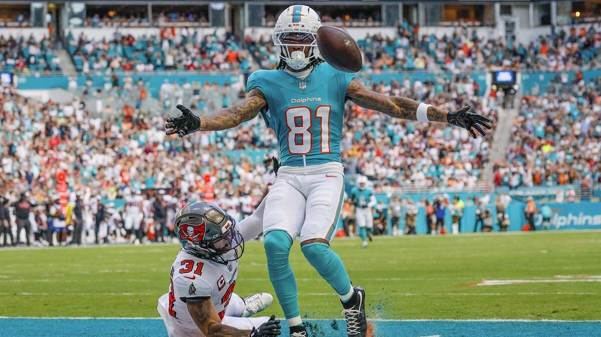 El wide receiver de los Dolphins Theo Wease Jr. (81) anota un touchdown sobre la marca del safety de los Buccaneers de Tampa Bay Antoine Winfield Jr., en el partido celebrado el 28 de diciembre de 2025 en el Hard Rock Stadium en Miami Gardens, Florida. 