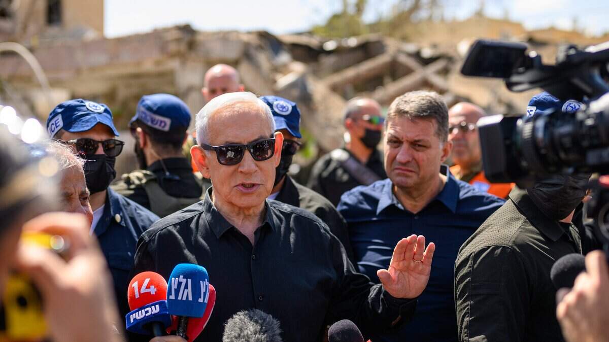 El primer ministro israelí, Benjamin (Bibi) Netanyahu, acompañado por el alcalde de Dimona, Benny Biton (izq.), habla con los medios mientras visita la zona destruida por un misil balístico iraní la noche anterior, que dejó más de 50 residentes heridos, el 22 de marzo de 2026 en Dimona, Israel.