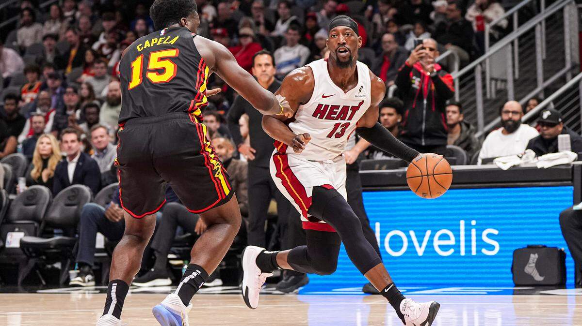 El pívot de Miami Heat, Bam Adebayo (13), dribla ante el pívot de Atlanta Hawks, Clint Capela (15), durante la primera mitad en el State Farm Arena, este 28 de diciembre de 2024; en Atlanta, Georgia.
