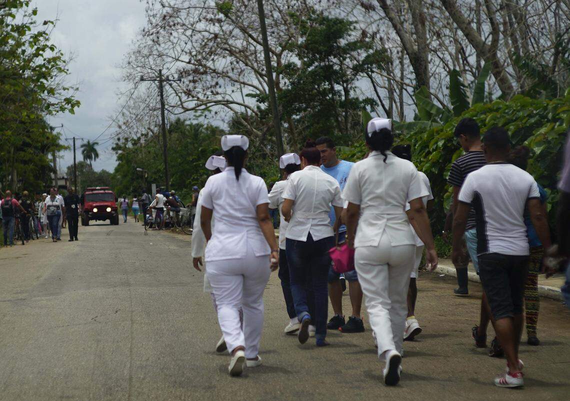 Nurses head toward the crash of a passenger plane carrying 104 passengers and several Mexican crew members that went down in a field shortly after taking off from Jose Marti International Airport in Havana.