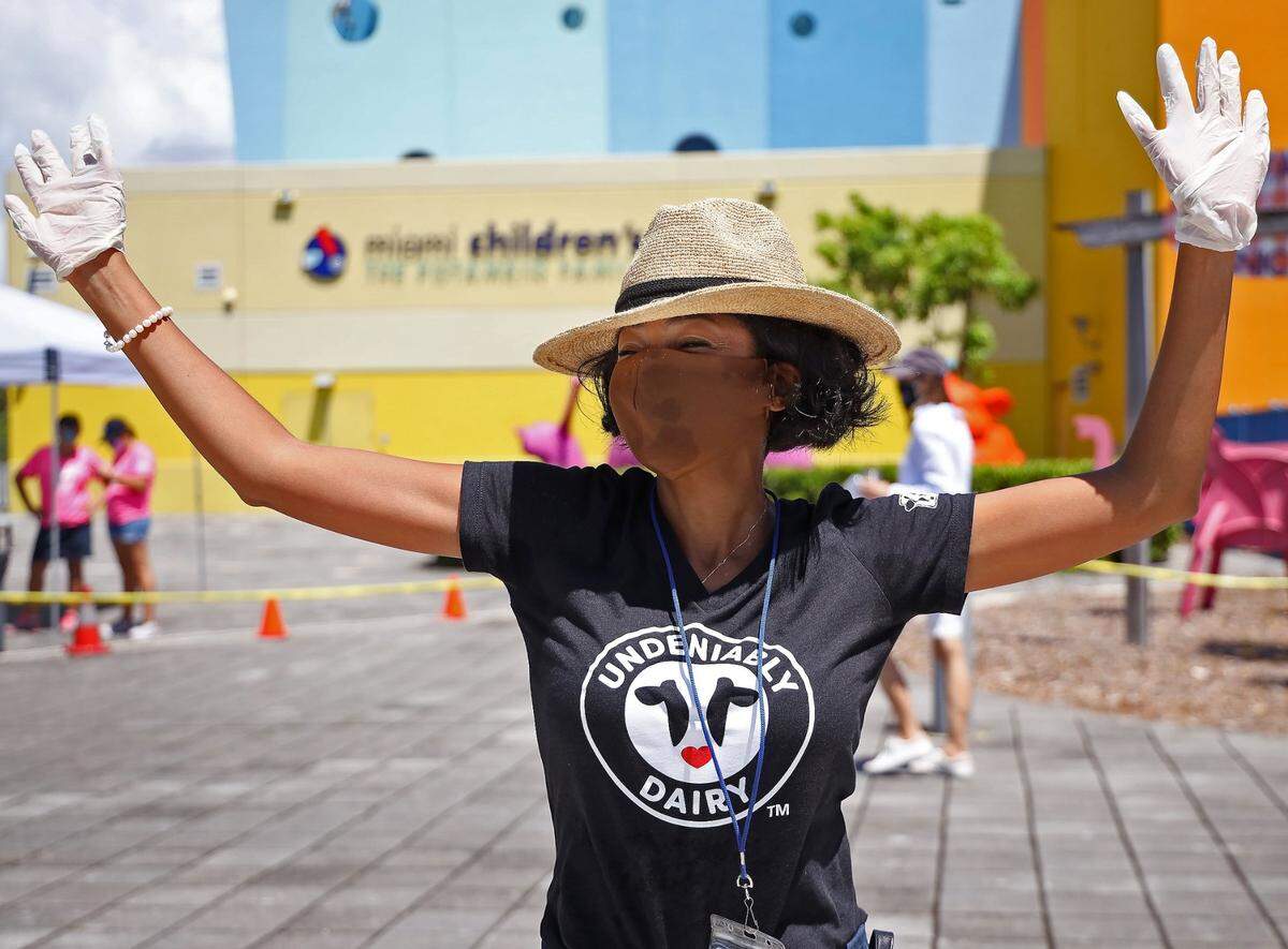 Miami Children’s Museum CFO Korollan King raises her hands while dancing as she helped hand out ice cream on National Ice Cream Day on July 19, 2020, at the museum.