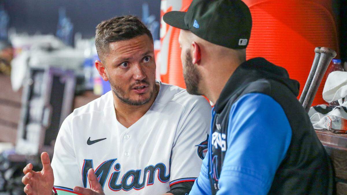 El torpedero de los Marlins Miguel Rojas (izq.) conversa con el receptor Jacob Stallings en el dugout durante el partido contra los Nacionales de Washington, celebrado el 7 de junio de 2022 en Miami.
