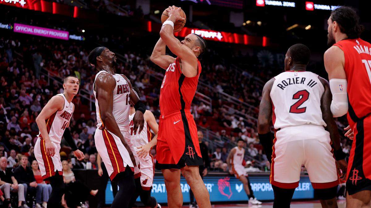 El delantero de los Houston Rockets, Dillon Brooks (9), lanza desde dentro contra el pívot de los Miami Heat, Bam Adebayo (13), ante la mirada de Tyler Herro (14) y Terry Rozier (2) en el Toyota Center.el 29 de diciembre de 2024; Houston, Texas.