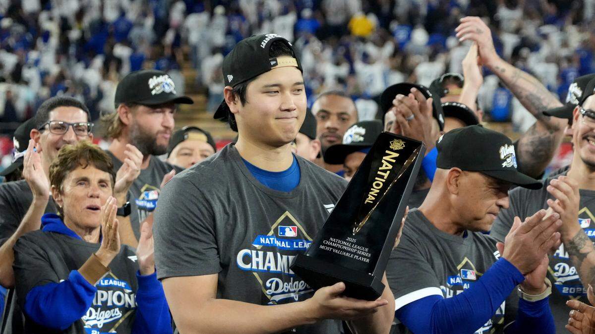 El astro de los Dodgers Shohei Ohtani recibe el trofeo de Jugador Más Valioso de la Serie de Campeonato de la Liga Nacional, el viernes en Los Angeles.
