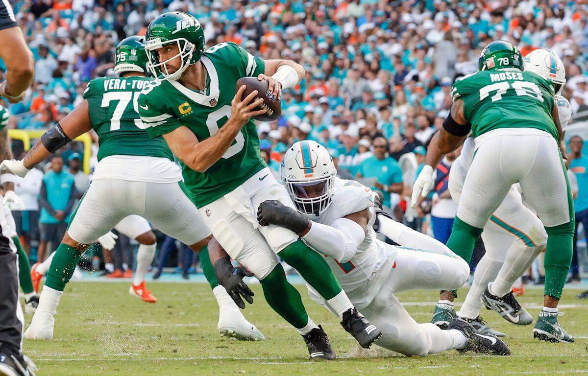 El linebacker de los Dolphins Emmanuel Ogbah derriba al quarterback de los Jets de Nueva York Aaron Rodgers, en el partido celebrado el 8 de diciembre de 2024 en el Hard Rock Stadium en Miami Gardens, Florida.