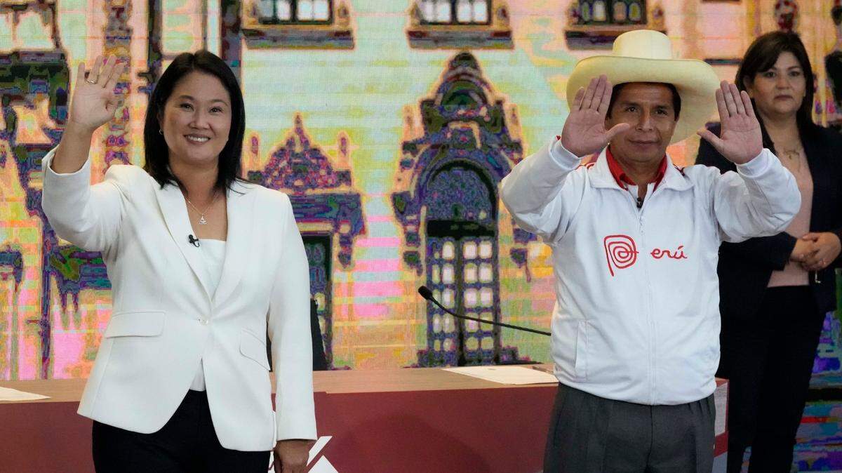 Los candidatos a la presidencia de Perú Keiko Fujimori (izq.) y Pedro Castillo saludan a la prensa al final de un debate el 30 de mayo de 2021 en Arequipa.