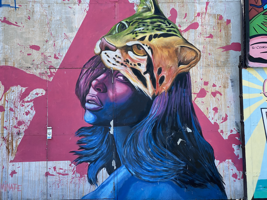 A woman with a tiger on her head is painted on a wall in the Wynwood neighborhood of Miami.