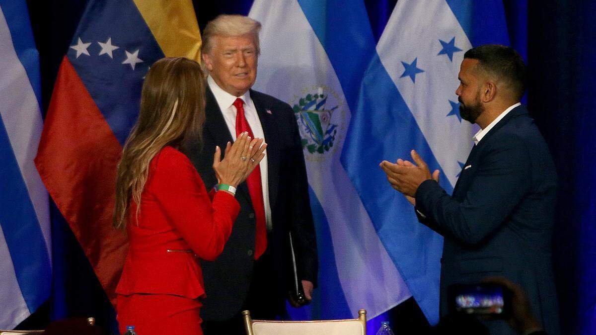 Karla Salvatierra (left) and Hiram Turrull, welcomed U.S President Donald J. Trump as he enters the stage as he meets with a group of South Florida community members during the Latinos for Trump Roundtable at the Trump National Doral in Doral Florida, on Friday, September 25th, 2020.