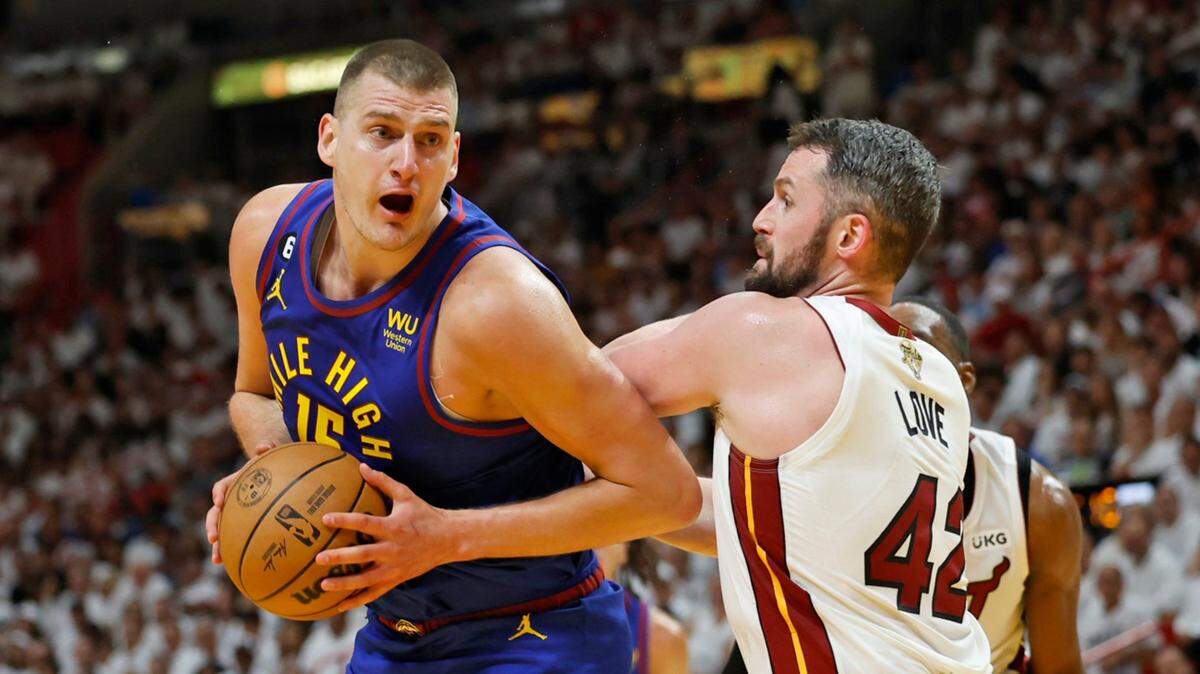 El centro de los Nuggets de Denver Nikola Jokic (izq.) trata de pasar la marca de Kevin Love, del Heat, en el tercer partido de las Finales de la NBA, celebrado el 7 de junio de 2023 en Miami.