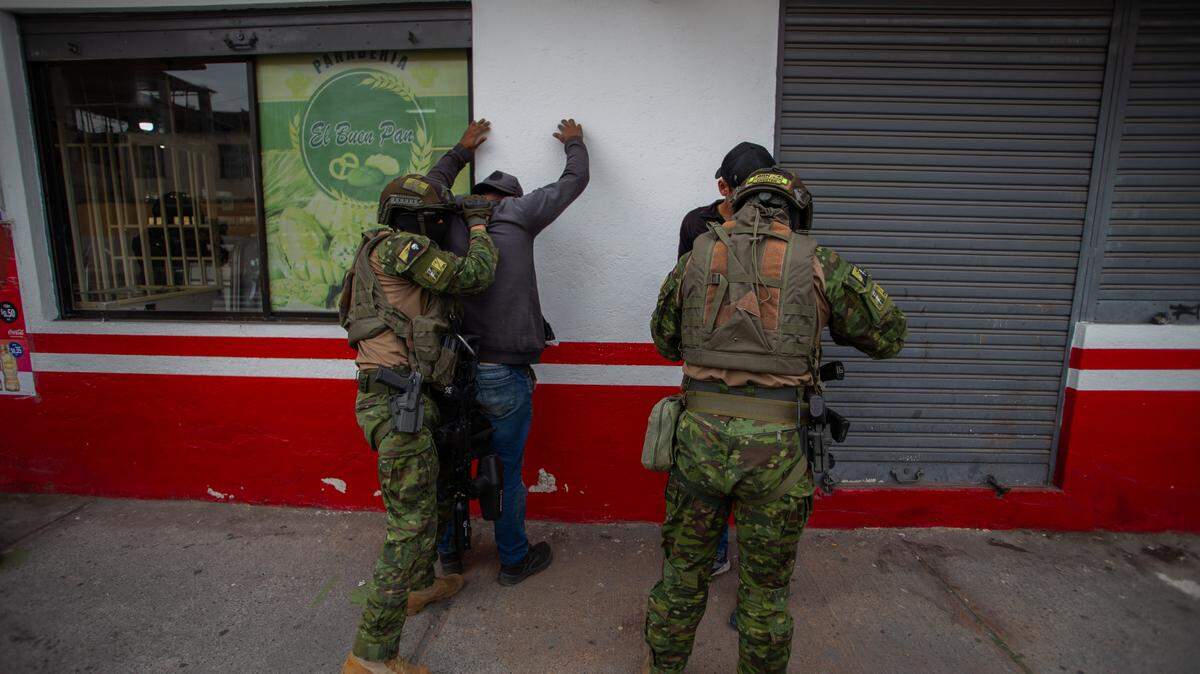 Agentes de la fuerzas armadas de Ecuador detienen a dos personas como parte de lucha contra la escalada de violencia de las bandas criminales, el jueves 11 de enero de 2024, en Quito.