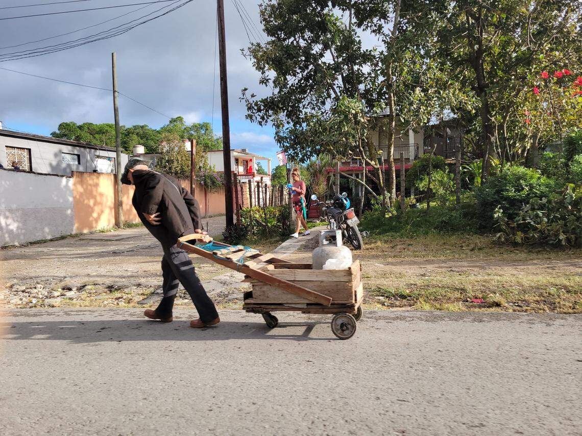 An elderly man carries a gas tank in Cienfuegos. The harsh living conditions in Cuba force older people to make extraordinary efforts to survive.