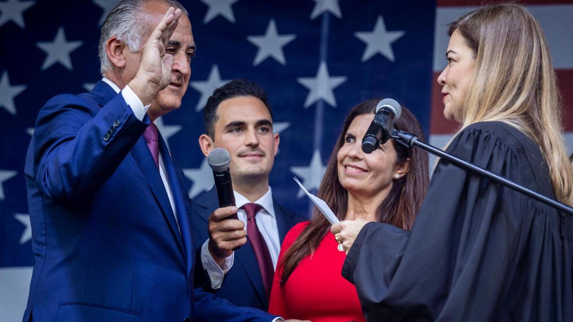 Esteban “Steve” Bovo, left, raises his right hand while being sworn in as Hialeah’s mayor on Nov. 5. Holding the mic is Bovo’s stepson, Hialeah Councilman Oscar De La Rosa. De la Rosa resigned on Tuesday to avoid the perception of a conflict.