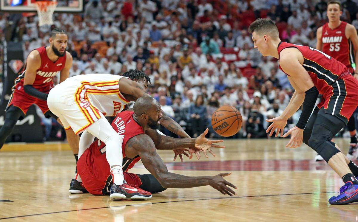 El centro del Heat Dewayne Dedmon (centro) recupera una pelota perdida en el quinto partido del playoffs de primera ronda, ante los Hawks, celebrado el 26 de abril de 2022 en Miami.