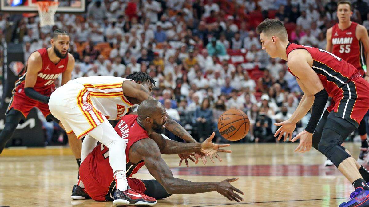 El centro del Heat Dewayne Dedmon (centro) recupera una pelota perdida en el quinto partido del playoffs de primera ronda, ante los Hawks, celebrado el 26 de abril de 2022 en Miami.
