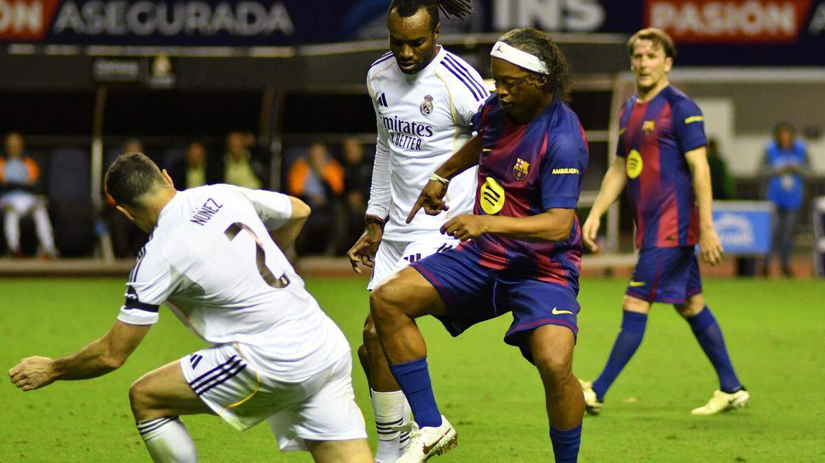 El astro brasileño Ronaldinho (der.), controla el balón ante el centrocampista español Antonio Núñez, durante el partido de exhibición entre las Leyendas del Real Madrid y del Barcelona en el Estadio Nacional de San José, Costa Rica, el 7 de febrero de 2026.