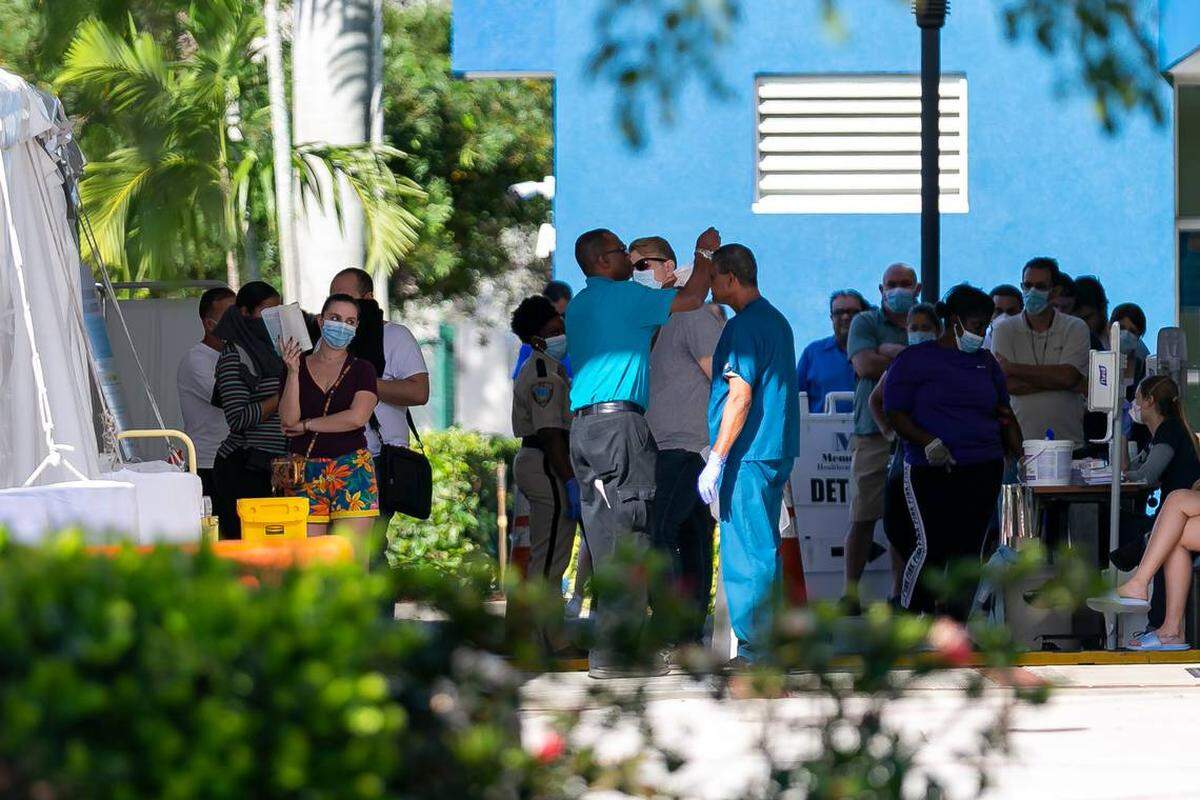 Gente hace fila para ingresar a una carpa de triaje afuera de la sala de emergencias del Memorial West Hospital en Pembroke Pines, Florida, el 16 de marzo de 2020.