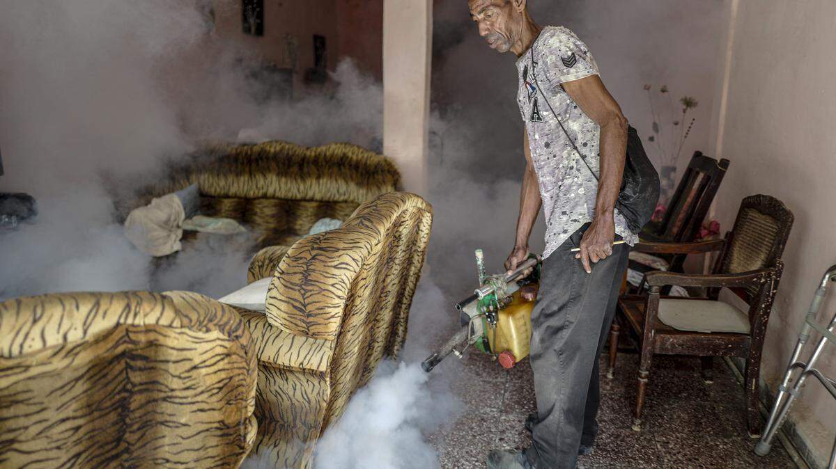An employee of Cuba's Ministry of Public Health fumigates a house in the Jesus Maria neighborhood of Havana on November 20, 2025. Health authorities admitted that an epidemic is affecting the entire country, as the accumulation of garbage, stagnant water, and blackouts has created ideal conditions for the proliferation of mosquitoes transmitting the virus. (Photo by ADALBERTO ROQUE / AFP) (Photo by ADALBERTO ROQUE/AFP via Getty Images)