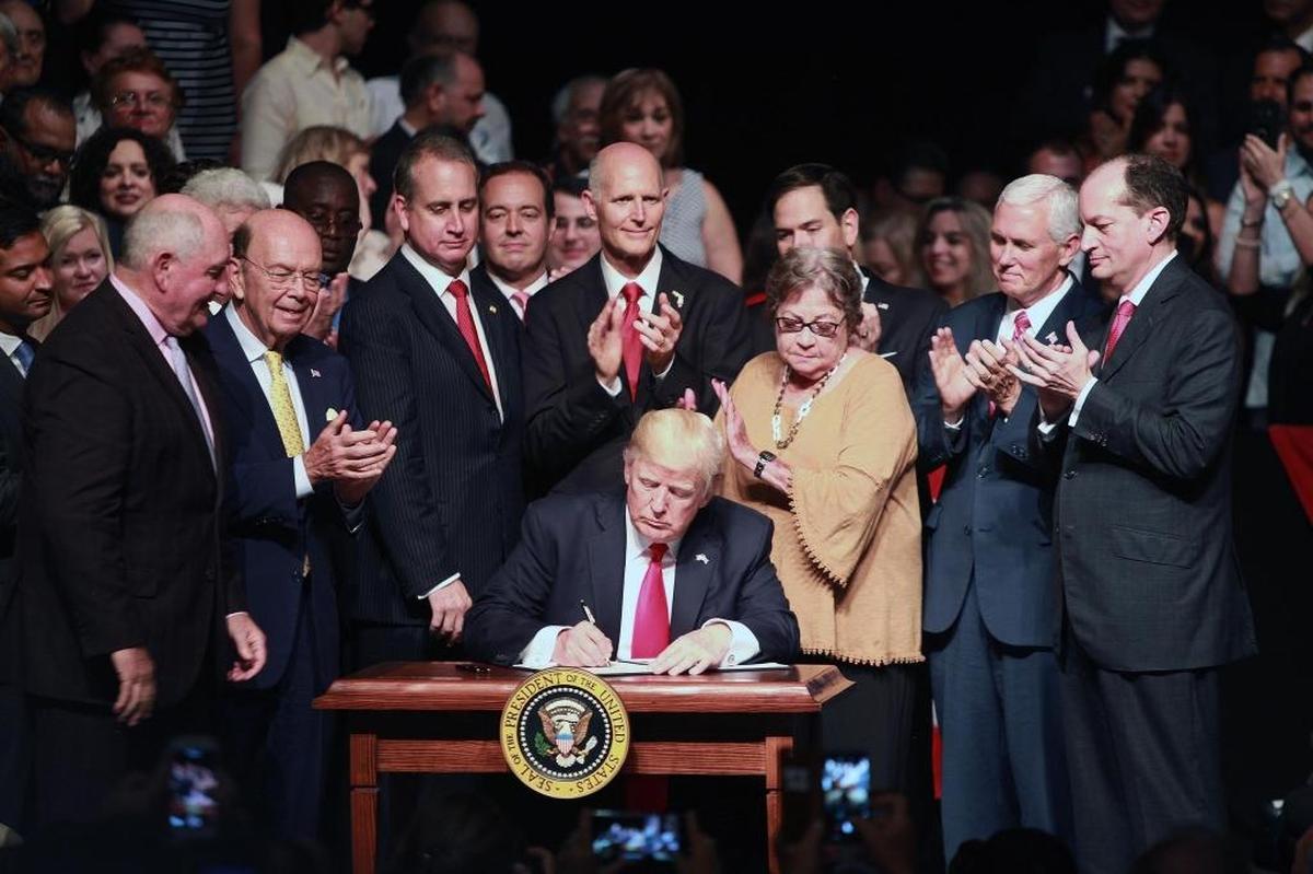 President Donald Trump signs a presidential memorandum in Miami in June 2017 setting out a new policy towards Cuba.