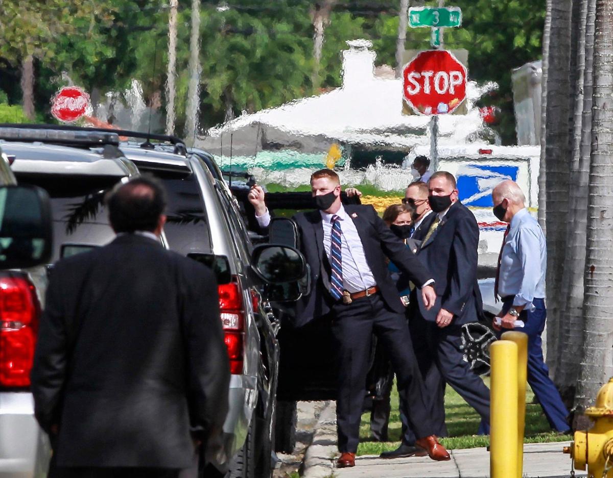 Joe Biden, right, is ushered by his Secret Service detail as he leaves the Little Haiti Cultural Complex during a brief visit. Biden courted Haitian-American leaders and voters on the last day to register to vote in Florida for the Nov. 3 presidential election on Monday, Oct. 5, 2020.