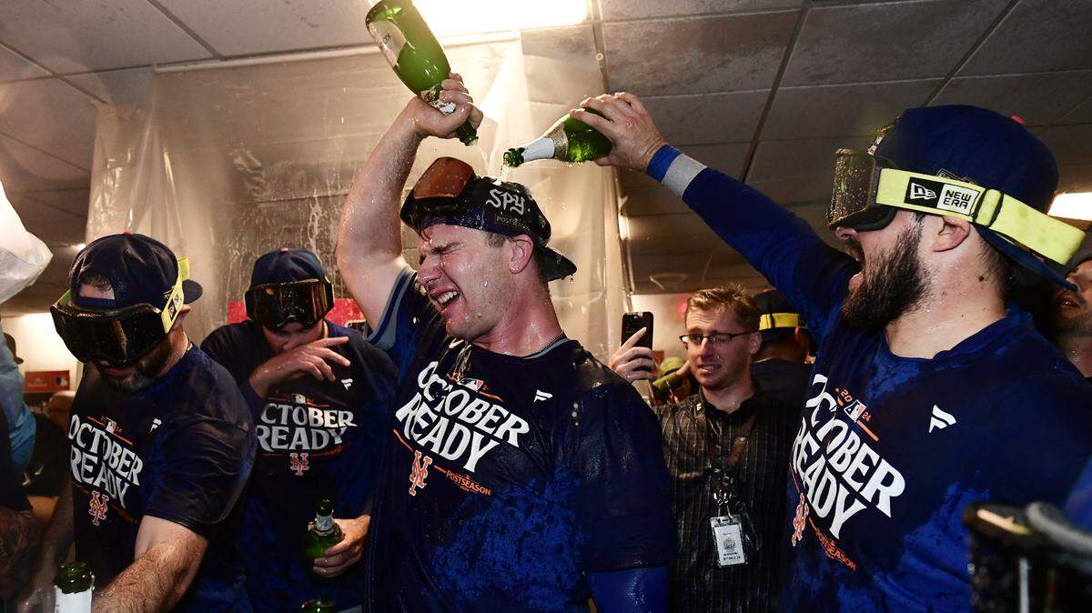 El primera base de los Mets de Nueva York Pete Alonso (centro) celebra en el vestuario con sus compañeros de equipo tras derrotar a los Cerveceros y avanzar a la Serie Divisional de la Liga Nacional, en el partido celebrado el 3 de octubre de 2024 en Milwaukee.