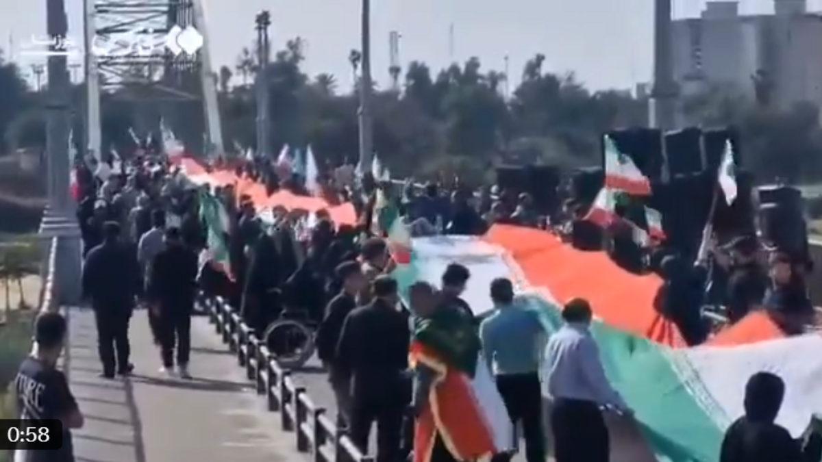 Imagen tomada de un video compartido en X el martes, 7 de abril de 2026, que muestra a decenas de personas en un puente ondeando banderas de Irán.