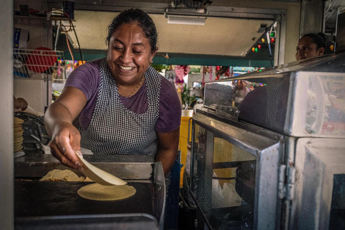 Yaneth, a cook, originally from Guerrero, Mexico. The photograph is part of the exhibit Belonging in Transit by Venezuelan photographer Carlos “Cali” Muñoz, who won the 2023 Photography Fellowship from the HistoryMiami Museum Center for Photography for emerging local documentary photographers.