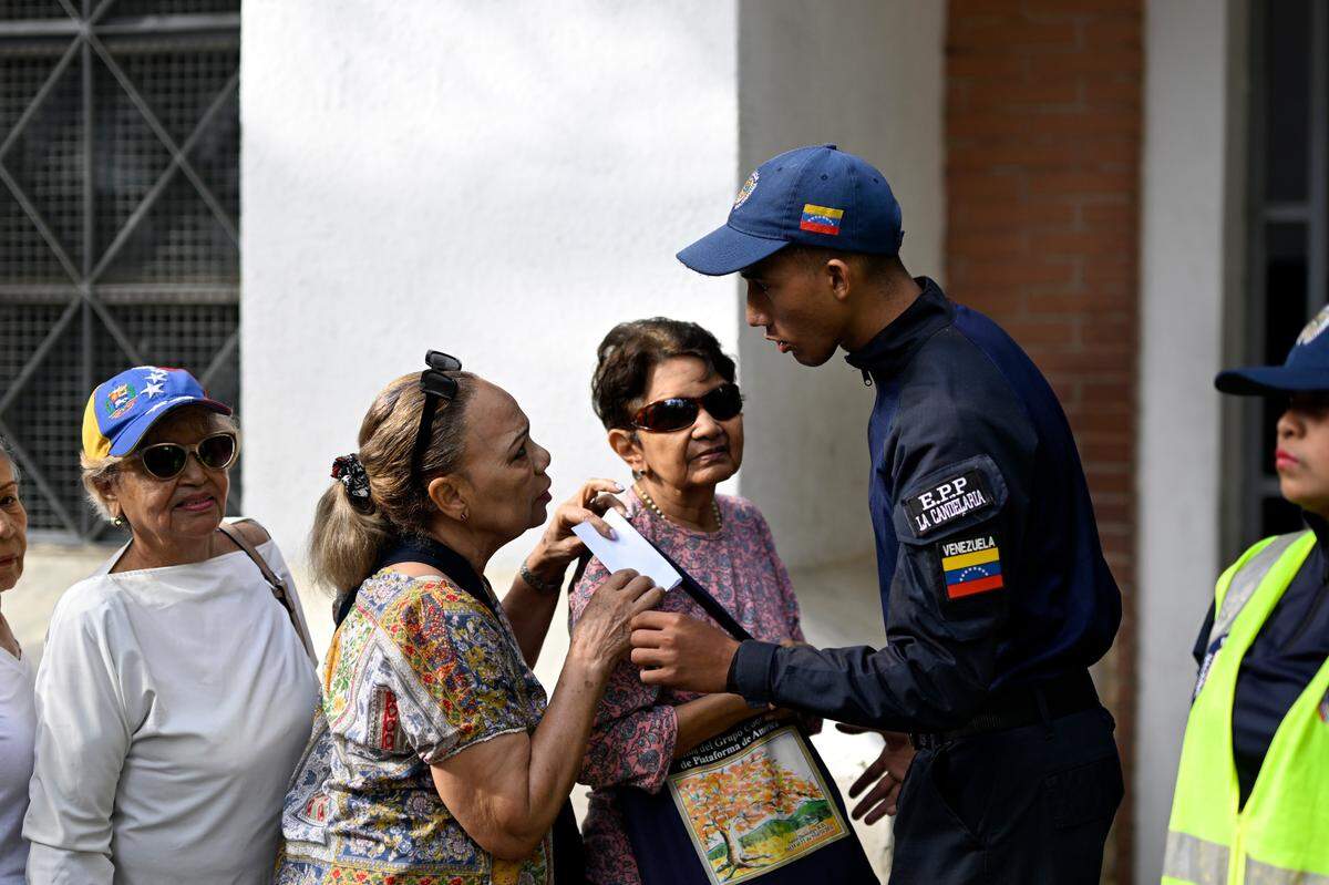 Votantes esperan para entrar a un centro electoral en Caracas, el domingo 28 de julio de 2024.